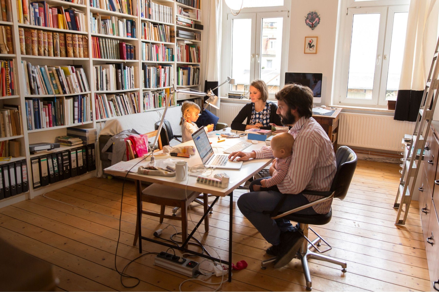 Male and female designer at work with two children